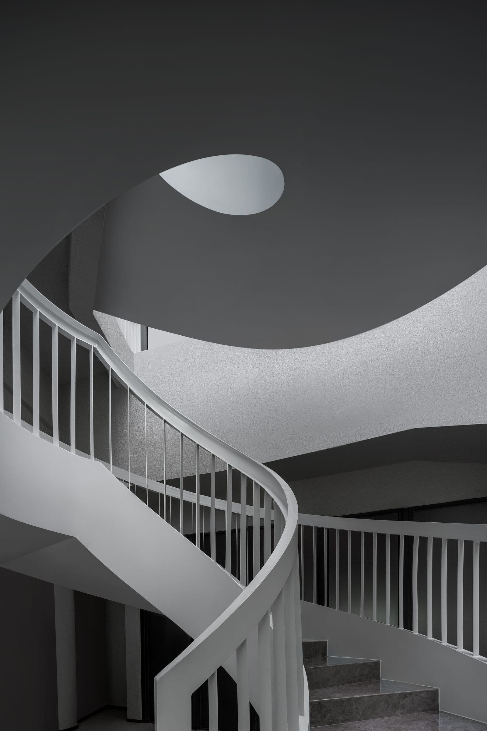 Modern white curved staircase with metal balusters